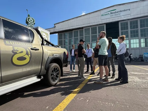 Visitors gathered around the Rattlesnake vehicle in front of the Airport Neuhardenberg hangar